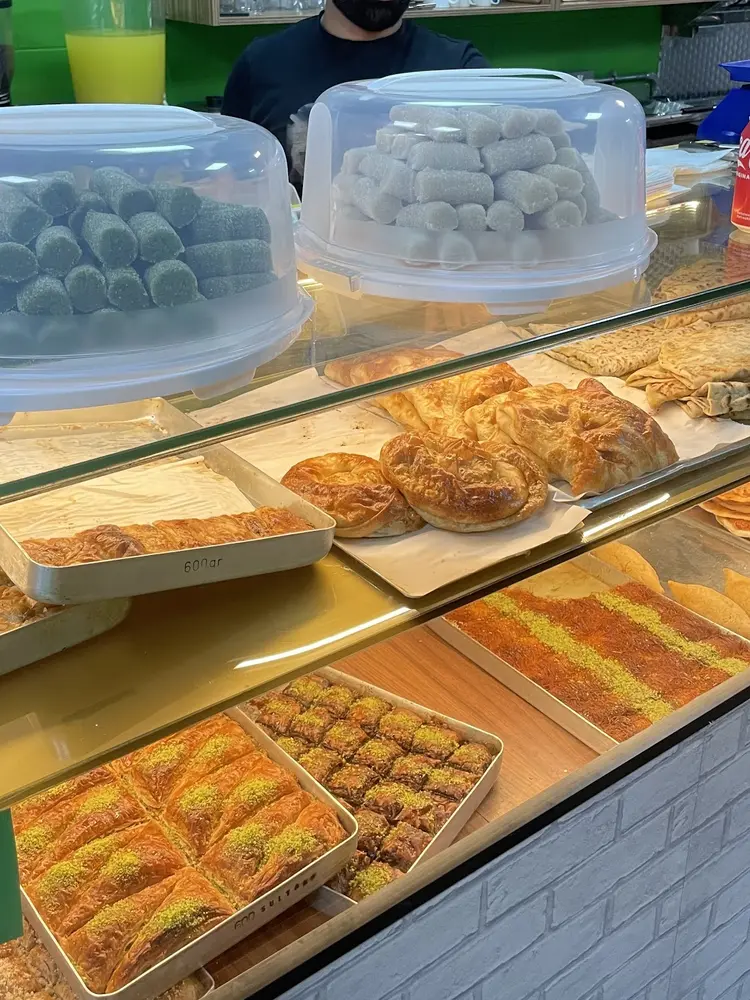 Glass counter filled with trays of baklava, börek and lahmacun